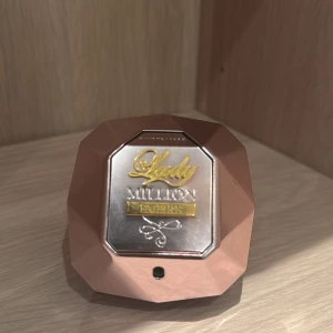 Lady Million Empire parfym - Snygg parfymflaska från Paco Rabanne, Lady Million Empire. Flaskan är formad som en diamant i roséguld med silver- och gulddetaljer på locket. Ger ett lyxigt intryck och är perfekt för dig som gillar exklusiva dofter.