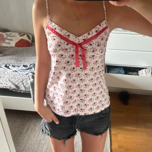 Blommig linnetopp med rosett - Supersöt linnetopp med småblommigt mönster. Använd fåtal gånger så i super bra skick! 