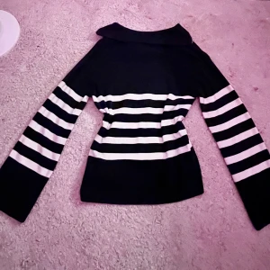 Randig stickad tröja från Kappahl - Säljer en svart och vit stickad tröja från Kappahl med half zip och bred krage. Tröjan har horisontella ränder, långärmad passform och är gjord i mjukt material som sitter snyggt på kroppen. Storleken funkar som både xs och s och är i mörkblå med vita ränder!