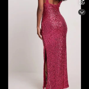 Glittrig rosa långklänning med slits - Säljer en superglittrig rosa långklänning med smala axelband och snygg slits bak. Klänningen har en figurnära passform och är täckt av paljetter som verkligen poppar. Perfekt för bal eller fest. Köpt för 699 o använd några timmar