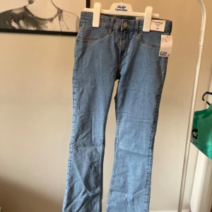 Ljusblå flared jeans från H&M - Snygga ljusblå jeans från H&M med flared ben och låg midja. Klassisk femficksmodell i mjukt bomullsjeansmaterial. Perfekta för dig som gillar en trendig och avslappnad look. Justerbar midja för bästa passform helt nya jeans 