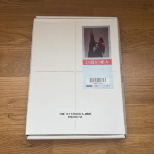 Querencia: The 1st Studio Album - Stilren och exklusiv fotobok med Chung Ha, fylld med coola bilder, texter och CD. Perfekt för dig som älskar K-pop och vill ha något unikt i samlingen. Innehåller även samlarkort och booklet med låttexter. En riktig must-have för fans och musikälskare!