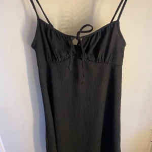 Svart kort klänning med knyt - Svart kort klänning med empire-waist, storlek S, aldrig använt 