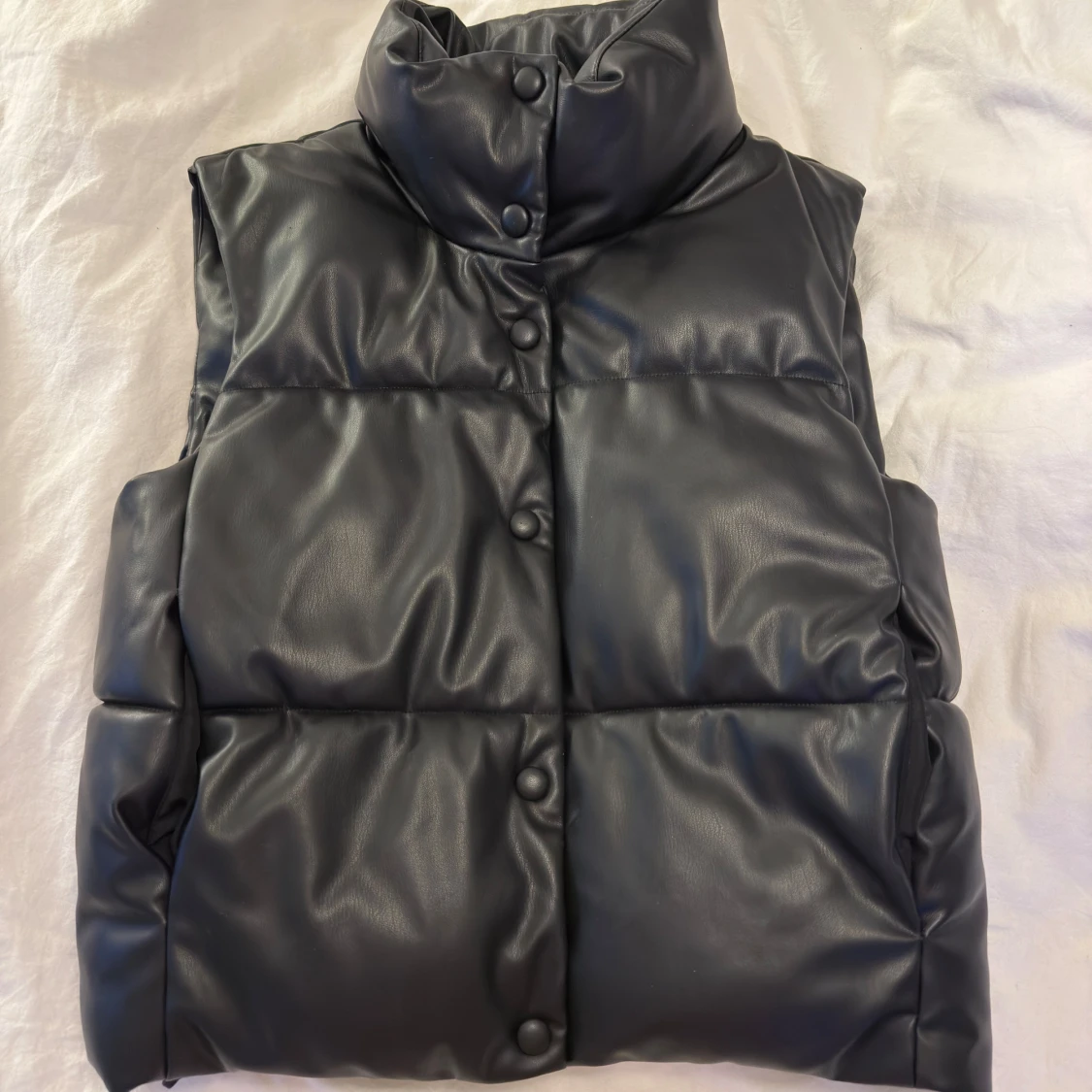 Svart dunväst i skinnimitation