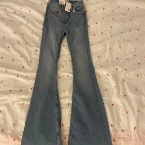 Ljusblå flare jeans XXS - Säljer ett par ljusblå flare jeans från Jeans Snake i storlek XXS. Modellen har kort längd och klassisk femficksdesign. Jeansen har utsvängda ben och är tillverkade i mjukt denimtyg med snygga sömmdetaljer. Perfekta för dig som gillar retrovibbar och statement-jeans.
