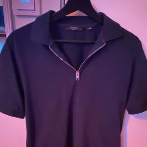 Mörkblå pikétröja med half zip Jack & Jones - Snygg marinblå pikétröja från Jack & Jones med klassisk krage och silverfärgad half zip-dragkedja. Skriv dm om intresse.