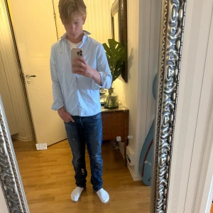 Ljusblå skjorta från GANT - Tja jag säljer denna Snygga ljusblå skjortan från GANT med klassisk krage och broderad logga på bröstet. Skjortan är nästan aldrig använt precis som den andra skjortan jag säljer alltså i princip helt sprillans ny. Den är också i Xs vilken gör dig som är runt 165-173 perfekt. Skjortan har långa ärmar, vita knappar och är gjord i mjuk bomull. Perfekt för dig som gillar stilrena och tidlösa plagg. Passar dig som vill ha en normal passform.