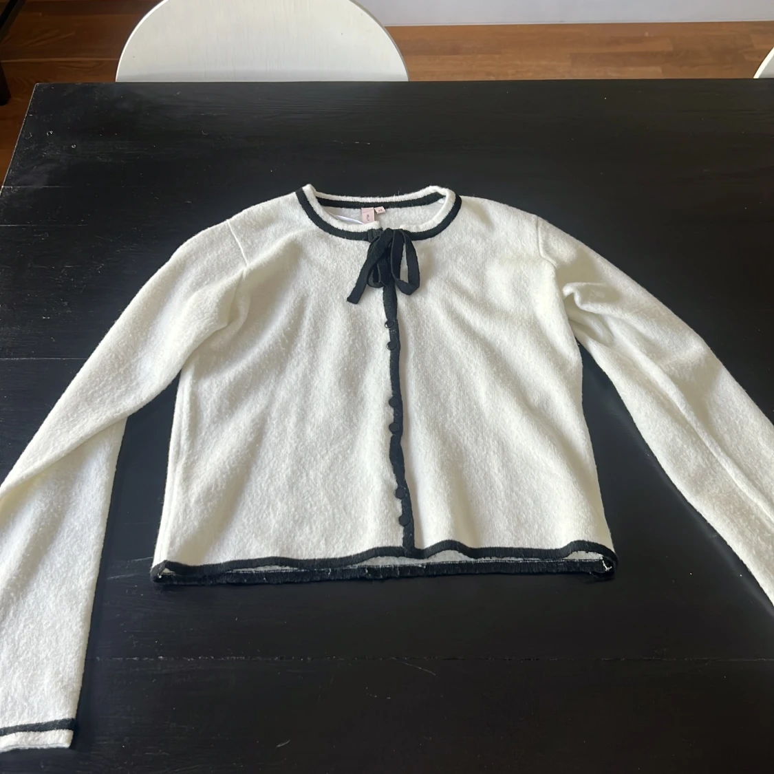 Vit kofta med svarta detaljer från Nelly