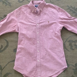 Rosa skjorta Polo Ralph Lauren slim fit - Säljer en rosa långärmad skjorta från Polo Ralph Lauren i slim fit-modell. Nypris 1500kr