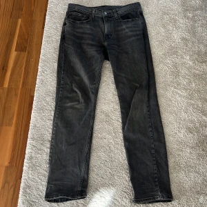 Levi's 514 svarta jeans W32 L32 - Svarta Levi's 514 jeans med klassisk femficksdesign och raka ben. Jeansen har en snygg tvättad finish och ikonisk läderpatch bak i midjan. Perfekta för dig som gillar en tidlös och clean look. Materialet är slitstarkt denim i bomull.
