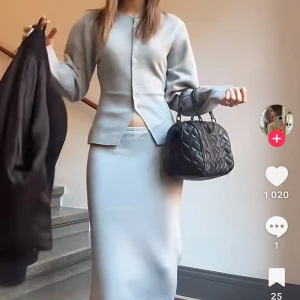 Ljusgrå sett i mjukt material - Supersnygg ljusgrå långkjol med clean och stilren look. Kjolen har en rak och tight passform som sitter riktigt snyggt på kroppen. Materialet är mjukt och stretchigt, perfekt för en chill och modern vibe. Passar dig som gillar minimalistisk stil och neutrala färger.