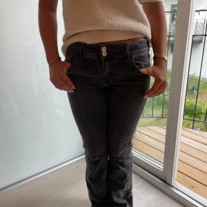 Lågmidjade svartgrå jeans  - Snygga svarta jeans från Gina Tricot i storlek 164. Passad för dig som är runt 160 cm. Modellen har bootcut-ben och klassisk femficksdesign med dubbla knappar i midjan. Jeansen är gråsvarta och sjukt bekväma💓