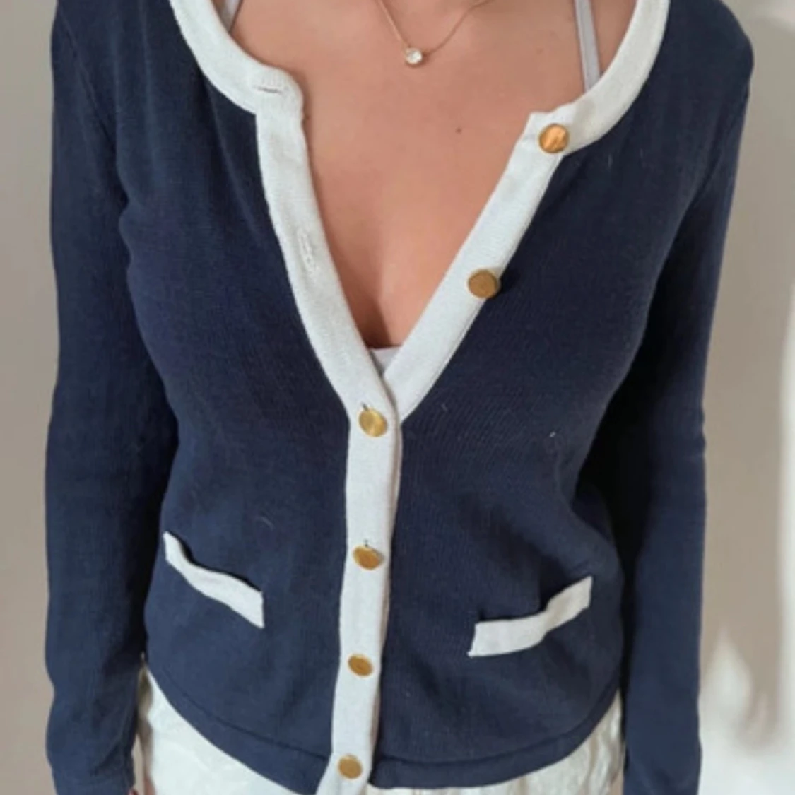 Mörkblå kofta med vita detaljer