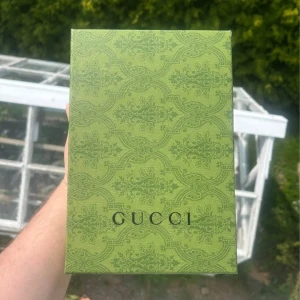 Svart Gucci keps med GG-logga - Snygg svart keps från Gucci med GG-monogram över hela kepsen. Kepsen har böjd skärm med svart kant och är tillverkad i slitstarkt tyg. Perfekt för dig som vill ha en lyxig streetstyle-accessoar med tydlig designerlook.