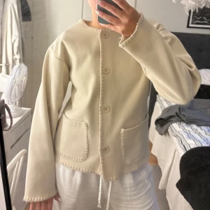 Beige  - En jättefin beige cardigan jacka från RYVLS. Jackan har stora fickor framtill, tydliga sömmar längs kanterna och knappar❣️ Storlek 170/176 men som en storlek S. Köpt på Kidsbrandstore för 599kr! 