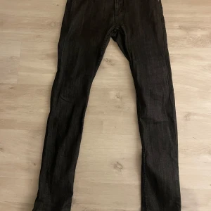 Svarta skinny jeans från ”humör” - Säljer ett par svarta skinny jeans från humör med klassisk diskret logga vid linningen. Jeansen har smal passform och är tillverkade i stretchigt denim som sitter snyggt och bekvämt. Perfekta för dig som gillar en stilren look.
