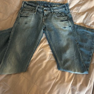 Blå jeans från havana med broderi - Säljer ett par ljusblå jeans från havana med coolt broderi på bakfickorna, bland annat en tjur i gul tråd. Jeansen har klassisk femficksdesign, låg midjade och bootcut med lite slitningar som är meningen att vara där. priset kan vi prata om