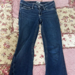 Mörkblå bootcut jeans från Gina Tricot  - Snygga mörkblå jeans från Gina Tricot med bootcut passform och kontrastsömmar. Baksidan har två fickor med dekorativa knappar och broderade detaljer. Klassisk femficksmodell och låg midja. Dom är inte ifrån miss me om det står det. Vill bli av med så pris kan diskuteras 💕