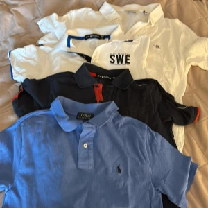 Pikétröjor från GANT, Sail Racing & Polo - Säljer ett gäng snygga pikétröjor i bomull från GANT, Sail Racing och Polo Ralph Lauren. Färgerna är vit, marinblå och ljusblå, vissa med coola detaljer som broderad logga, kontrastfärg på krage och tryck. Alla har korta ärmar och klassisk pikékrage med knappar. det är lite olika storlekar från cirka 12-16 