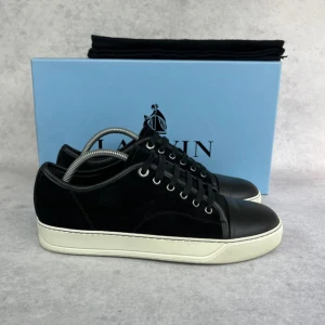 Lanvin DBB1 cap toe sneaker - – Condition: 9/10  - Size: 40/UK6  – What is included: Dustbag  – Retail price: 6000 + SEK  Please note that Lanvins fit big and our recommendation is to go one size down