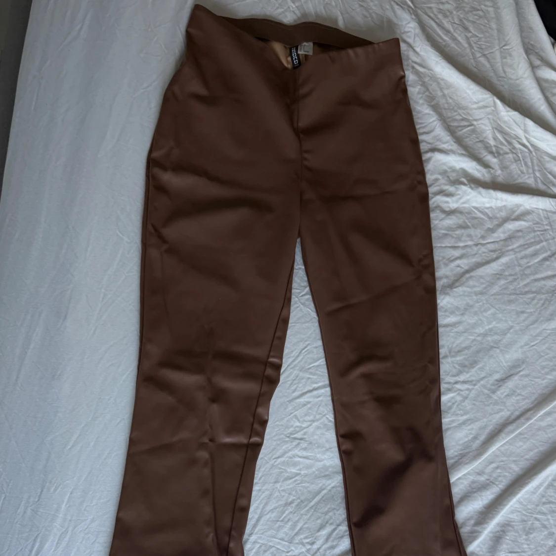 Bruna bootcut byxor i skinnimitation