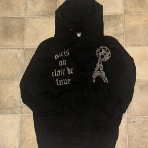 Svart hoodie med strass och Paris-tryck - Svart hoodie från BLINGLUCID i storlek L. Nypris 600kr