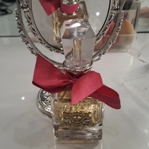 Juicy Couture parfym med röd rosett - Lyxig "parfymflaska" från Juicy Couture, använd tre gånger i lukt viva la juicy 50ml. Bara flaskan och inget annat.