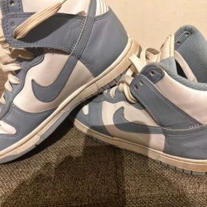 Nike ljusblå skor - Snygga Nike Dunk High sneakers i ljusblått och vitt skinn. 