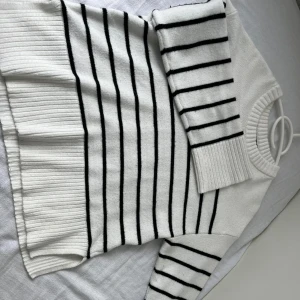 Vit och svart randig stickad tröja XS - Superfin vit stickad tröja från 157 med svarta ränder. Tröjan har lång ärm, ribbade muddar och bred ribbad nederkant med slits i sidorna. Perfekt för lager-på-lager och chill stil.