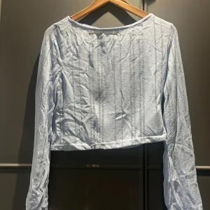 Ljusblå ribbad topp från Gina Tricot - Säljer en ljusblå långärmad topp från Gina Tricot i storlek XS. Toppen sitter pösigt och otroligt fin på. Materialet känns lätt och luftigt, perfekt för dig som gillar en chill och trendig vibe.