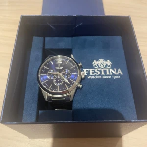 Festina herrklocka med blå urtavla - Snygg herrklocka från Festina med blå urtavla och silverfärgade detaljer. Kommer i originalask med Festina-logga. Perfekt accessoar för dig som gillar stilrena detaljer.