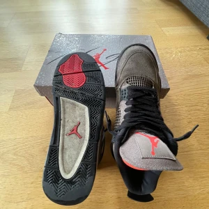 Air Jordan 4 Retro Taupe Haze - Säljer ett par Nike Air Jordan 4 Retro Taupe Haze med snygg mocka och meshdetaljer. Skorna har en brun och taupe färgskala med svarta och röda detaljer, samt den klassiska Jumpman-loggan på plösen och sulan. Perfekt för dig som vill sticka ut med en ikonisk sneaker. Storlek 42 fast är ganska tajta så skulle säga storlek 41/5