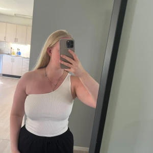 Vit ribbad oneshoulder topp - Säljer en vit ribbad topp med oneshoulder-design. Från Gina tricot, storlek s