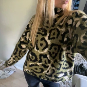 Leopardmönstrad stickad tröja - Säljer en stickad tröja med leopardmönster i grönt, svart och beige. Tröjan är polo. Super skön och cool!!