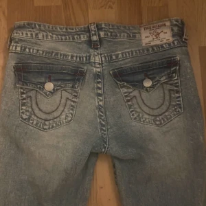 True Religion ljusblå bootcut jeans - Säljer ett par ljusblå bootcut jeans från True Religion. Hål vid knäna. ordinarie pris 1299kr men säljer för 700kr. Säljer dessa då det inte kommer till användning och endast använt fåtal gånger så är i mycket bra skick