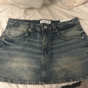 Blå jeanskjol Stradivarius, storlek 40 - Säljer denna super fina jeanskjolen ifrån stradivarius, köptes denna sommaren utomlands, storlek 40 med inbyggda short under. Aldrig använd