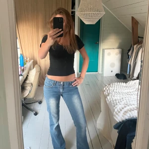 Blå bootcut jeans - Säljer ett par blå bootcut jeans från Miss Ivy. Jeansen har låg midja, fem fickor och snygga slitningar framtill. Dom har stretch så dome jättesköna. Det står 42 i dom, men det stämmer inte då dem passar mig som har S! 