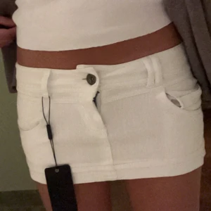Vit jeanskjol från Terranova - Supersnygg vit jeanskjol från Terranova!! Ca 24 cm lång, 38 cm rakt över midjan🥰ett litet hål finns, skriv privat om ni vill se. Väldigt enkelt att fixa och syns knappt! 