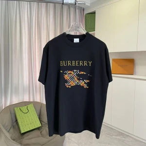 Svart Burberry t-shirt med tryck - Svart t-shirt från Burberry med stort färgglatt tryck och logga på bröstet. T-shirten har klassisk passform, rund halsringning och är tillverkad i mjuk bomull. Trycket har inslag av gult, rött och vitt i ett rutigt mönster.