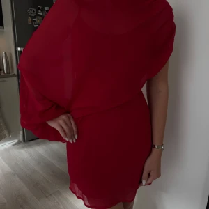 Röd omlottklänning med drapering - Säljer en röd kortklänning med snygg omlott-drapering, aldrig använd! I stl 36, säljs för 400kr🤍