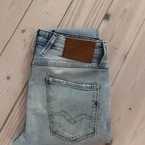 Replay Anbass jeans - Säljer ett par Replay Anbass jeans i ljusblå tvätt. Sitter riktig bra. Obs finns ett hål på ena knäet. Storlek 29W-32L. Hör av er vid minsta fundering 