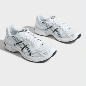 Vita Asics sneakers med svarta detaljer - Snygga vita Asics sneakers med svarta detaljer. Perfekta för dig som gillar en clean och fräsch look till vardags eller träning. Ordinarie pris 1200