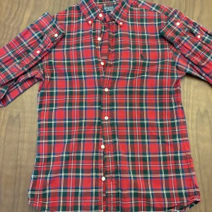 Rutig skjorta från Polo Ralph Lauren - Skitsnygg och stilren rutig skjorta från Polo Ralph Lauren med klassisk krage och knappar framtill. Skjortan är i S men kan upplevs som lite mindre i sin storlek så passar för både S och XS. Jag har int använt denna alls mycket men har funnits i garderoben ett tag. En skjorta som passar i alla slags tillfällen! Är det något så tveka inte att hojta till! Pris går alltid att diskutera.