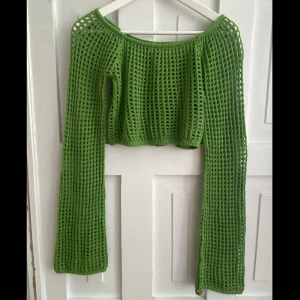 Grön mesh bolero från Urban Outfitters - Säljer en grön mesh bolero från Urban Outfitters. Tröjan har lång ärm, är virkad med hålmönster och har en bred, rund halsringning. Perfekt för lager-på-lager och till sommaren 💚 använt den typ 3 gånger.