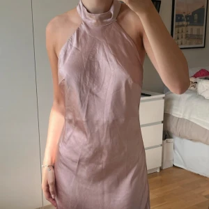 Rosa halterneck miniklänning från NAKD - Mycket bra skick. Fint och lent material. Säljer då den inte passar mig. Perfekt till finare tillfällen!