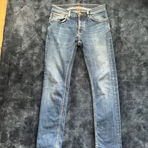 Blå jeans från Nudie Jeans - Säljer ett par klassiska blå jeans från Nudie Jeans i modellen w30/l32. Jeansen är i färgen indigo myth och passformen grim Tim (Slim fit). Hör av er för fler frågor. Mvh Charlie