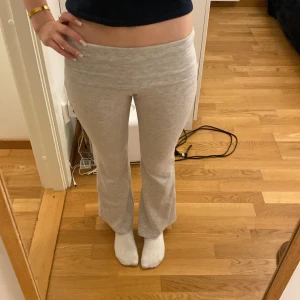 Ljusgrå mjukisbyxor med bootcut Kappahl  - Säljer ett par ljusgrå mjukisbyxor med bootcut och hög midja. Byxorna är i mjukt material och har en bred linning upptill. Perfekta för en avslappnad stil. Tror att det är storlek 146/152 men har klippt bort lapparna.