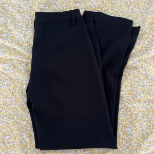 Svarta kostymbyxor från BikBok - Svarta kostymbyxor från BikBok med klassisk rak passform och hällor i midjan. Byxorna är i storlek 40 