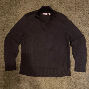 En quarter zip från Calvin Klein - Säljer en mörkgrå quarter zip från Calvin Klein. Storlek M som har en jättebra passform nör den inte är så pass slim men inte loose. Säljer för har själv slutat använda den. 
