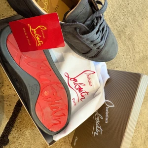 Grå sneakers från Christian Louboutin - Ett par loubs som är som nya. Storlek 42. Kan fraktas om köparen står för frakten. Kan gå ner i pris om det blir en snab affär  